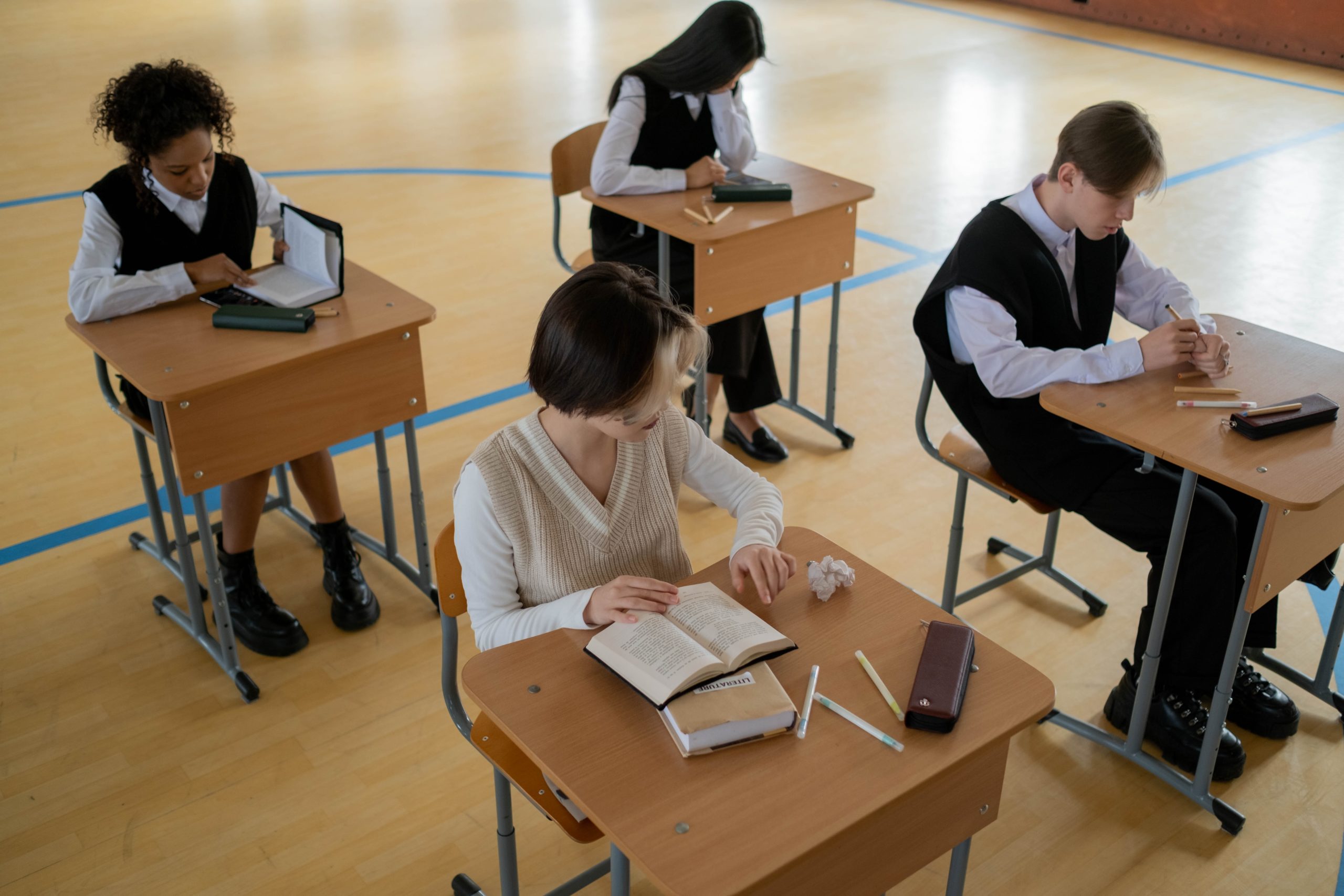 School pupils learning at desks in a school hall